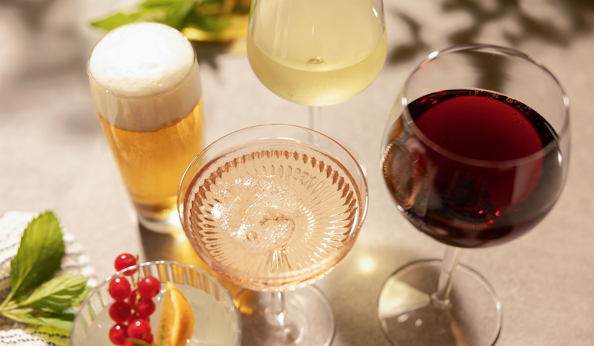 Laseja olutta, valko-, rosé- ja punaviiniä, cocktailin ja marjojen kera.