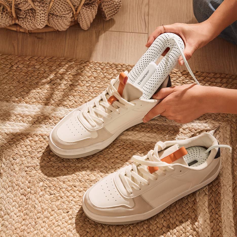 Silvercrest-kengänkuivain valkoisissa tennareissa punotulla matolla.