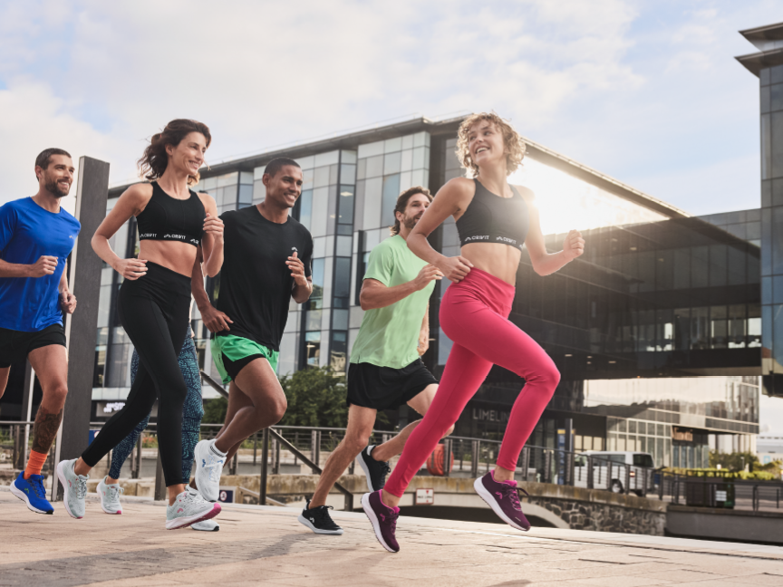 Ryhmä ihmisiä juoksee ulkona käyttäen Decathlonin urheiluvaatteita.