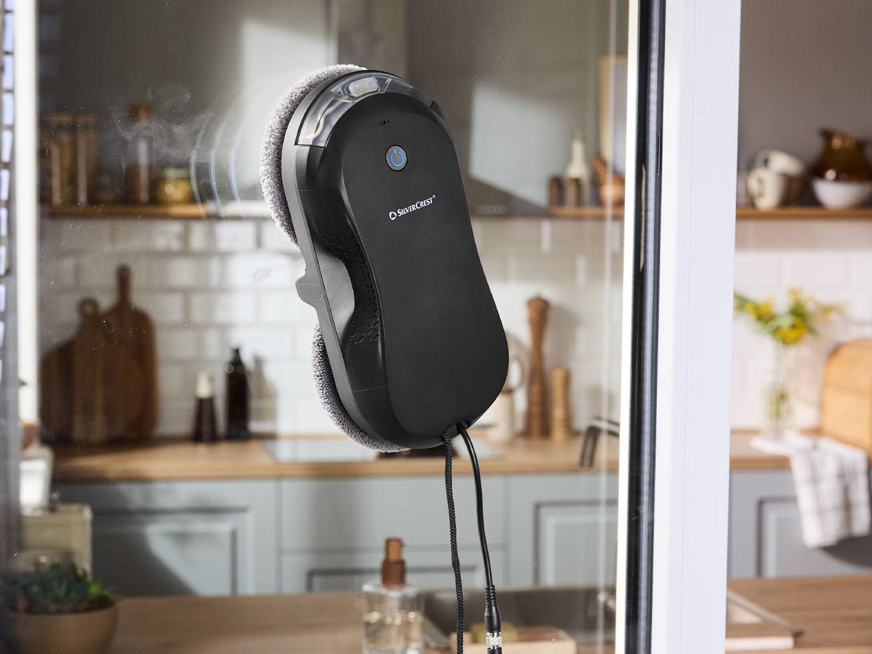 Silvercrest ikkunanpesurobotti ikkunaruudulla, keittiö taustalla.