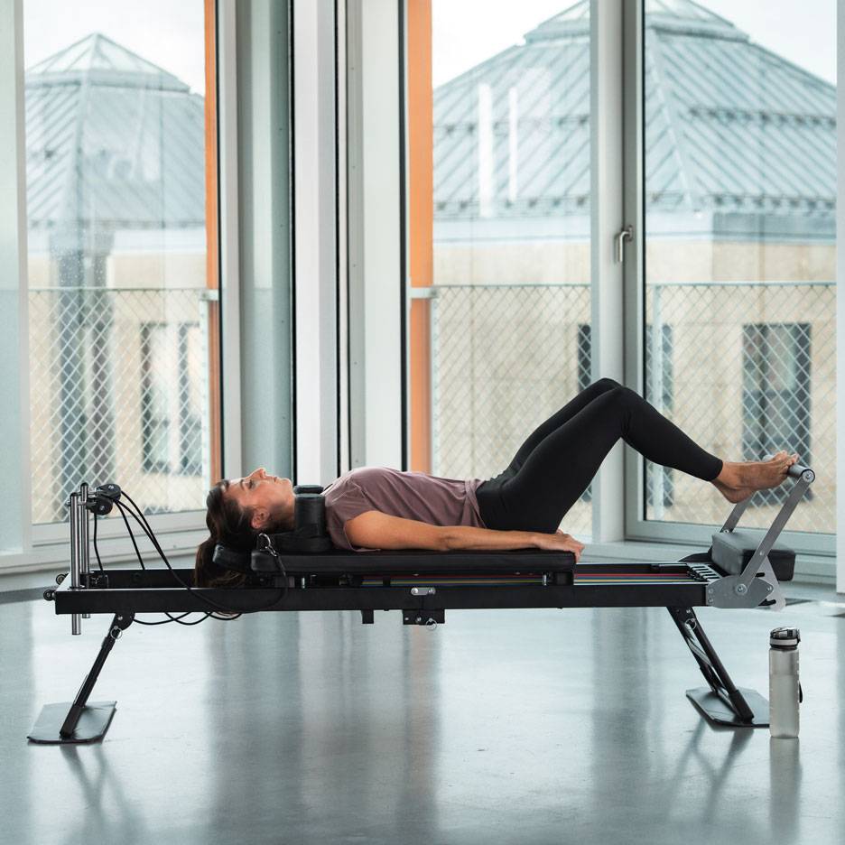Nainen tekee Pilates-harjoituksia reformer-laitteella.