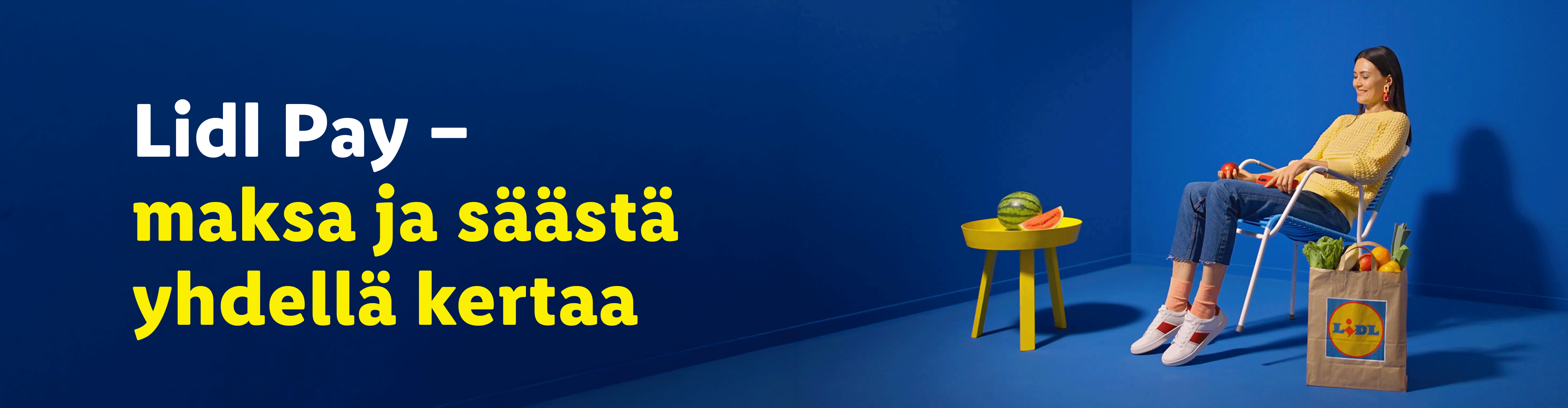 Nainen rentoutuu tuolissa ostoskassin ja vesimelonin vieressä; teksti: 'maksa ja säästä yhdellä kertaa'.