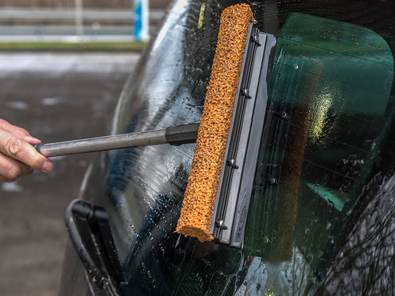 Ikkunanpesuri pitkällä varrella puhdistaa auton takalasia.