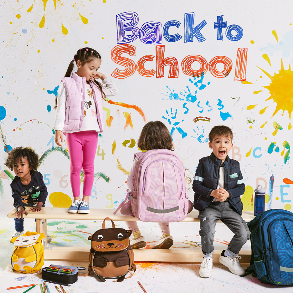 Neljä lasta reppujen ja koulutarvikkeiden kanssa, 'Back to School' -teksti värikkäällä taustalla.