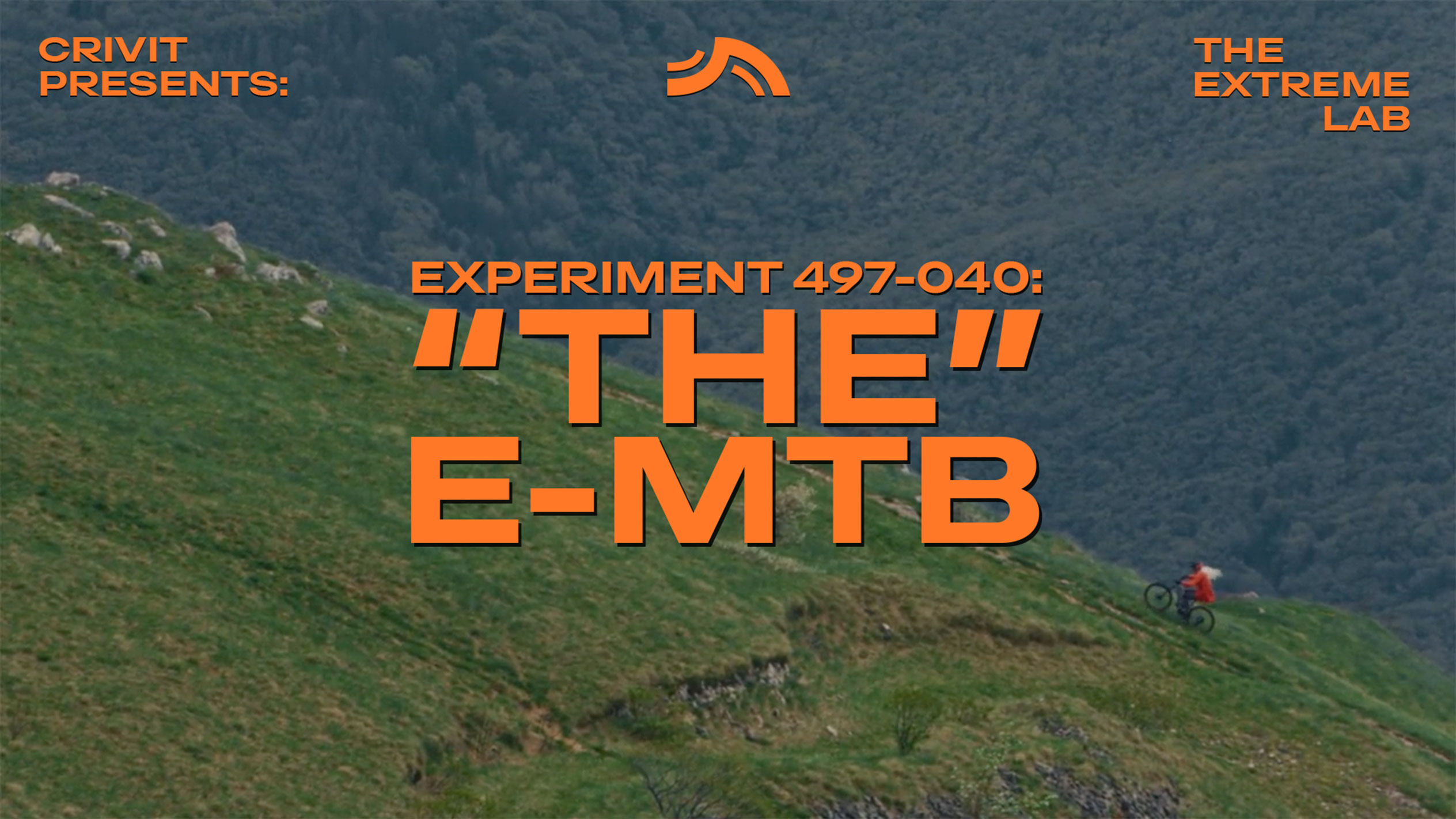 Maastopyöräilijä ruohoisella rinteellä, tekstillä 'THE E-MTB' ja 'THE EXTREME LAB'.