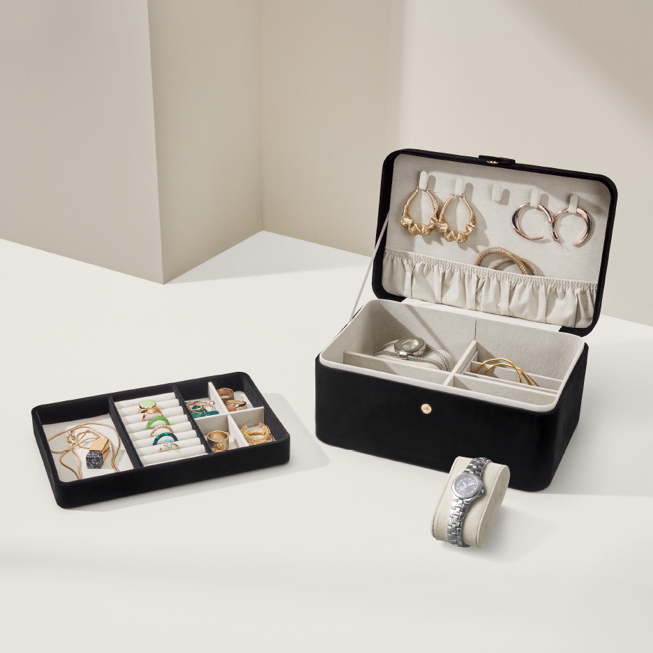 Musta korurasia, jossa on korvakoruja, sormuksia, rannekoruja ja kelloja.