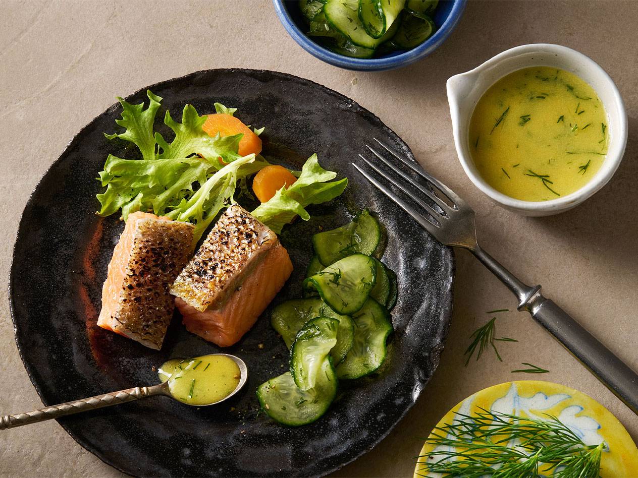 Lohifileet, kurkkusalaatti ja vihreä salaatti keltaisella kastikkeella.