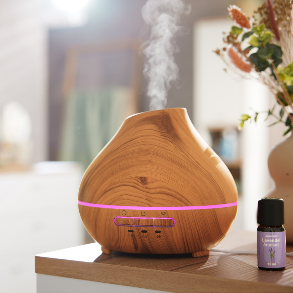 Puunvärinen aromidiffuusori, jossa on violetti valo ja eteerinen laventeliöljy.