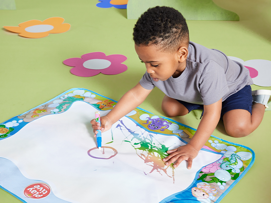 Pieni lapsi piirtää Play-Doh vesikynällä Play-Doh vesipiirivaliolla.