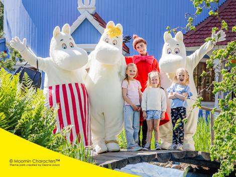 Muumihahmot ja lapset poseeraavat teemapuistossa.