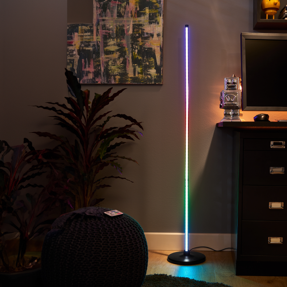 Värikäs LED-lattiavalaisin olohuoneessa, jossa on kasveja ja taidetta.